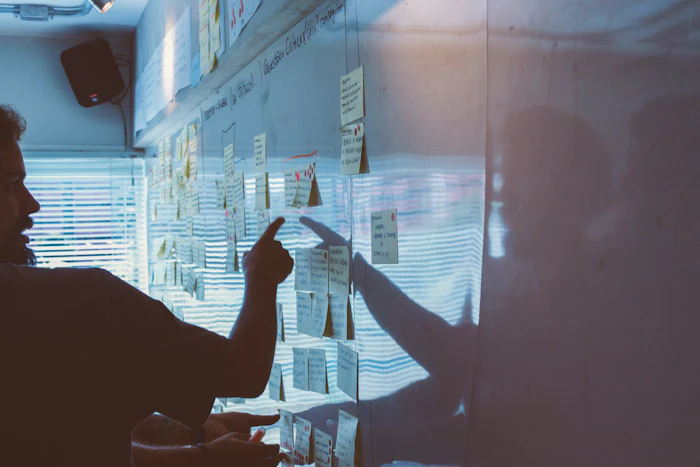 Person pointing at plans on a wall